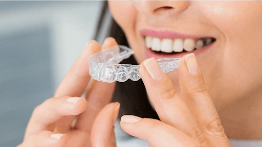 A patient puts on Invisalign for crowded teeth.